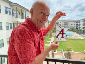 Rodger Erickson holding stained glass Augsburg logo